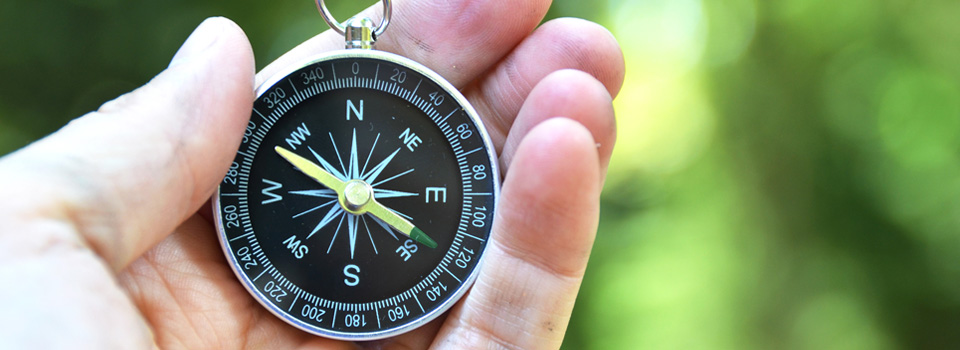 Palvelut sivun headerkuva kompassi kädessä