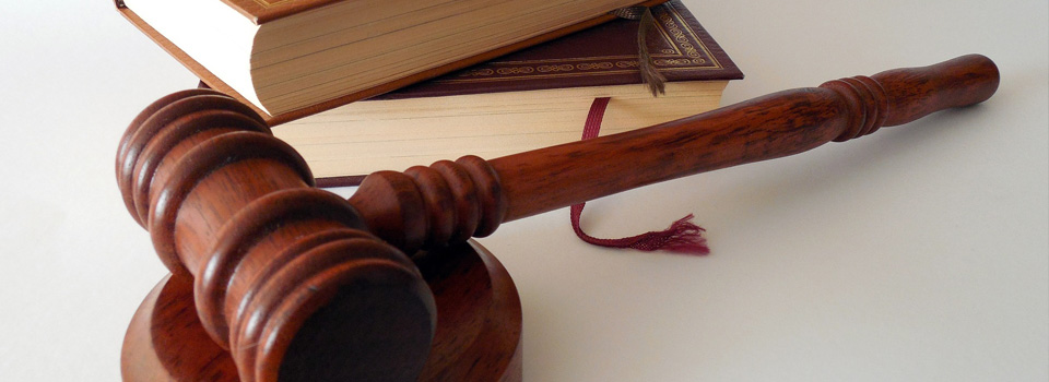 Työsuhdeasiat sivun headerkuva tuomarinnuija, lakikirjoja pöydällä